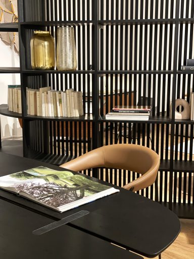 Chaise design moderne à côté d'une étagère avec des livres et des objets décoratifs.